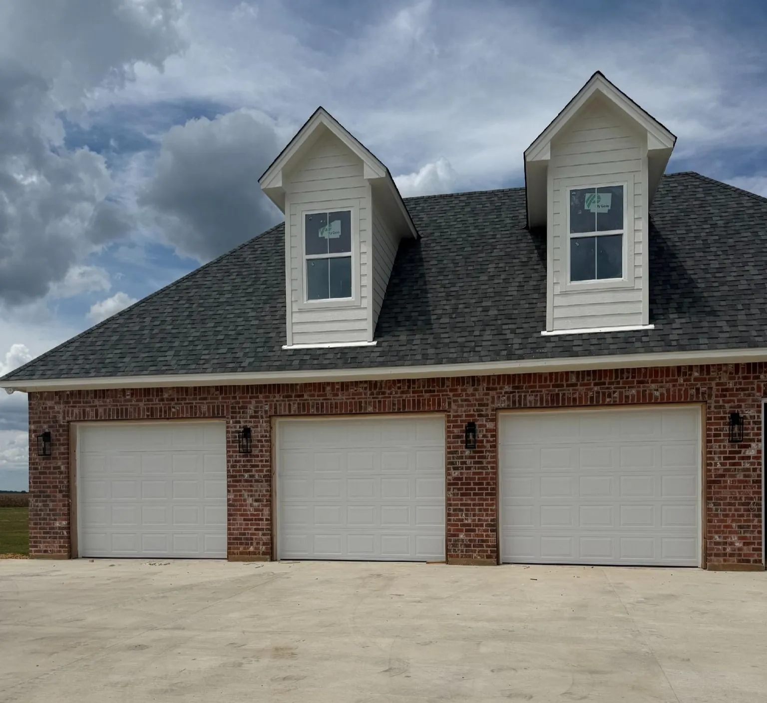 Three-bay brick garage with new steel doors