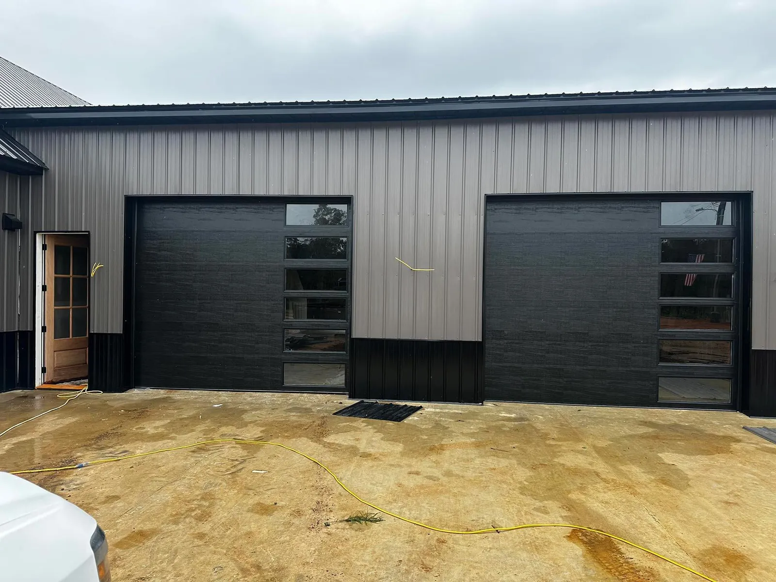Two commercial sectional doors on a metal building