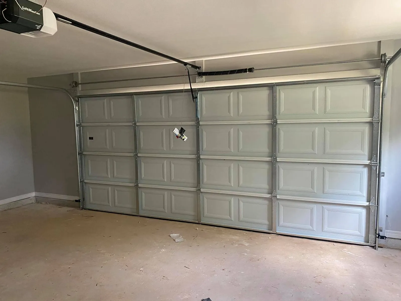 Garage interior with a well maintained sectional door and opener