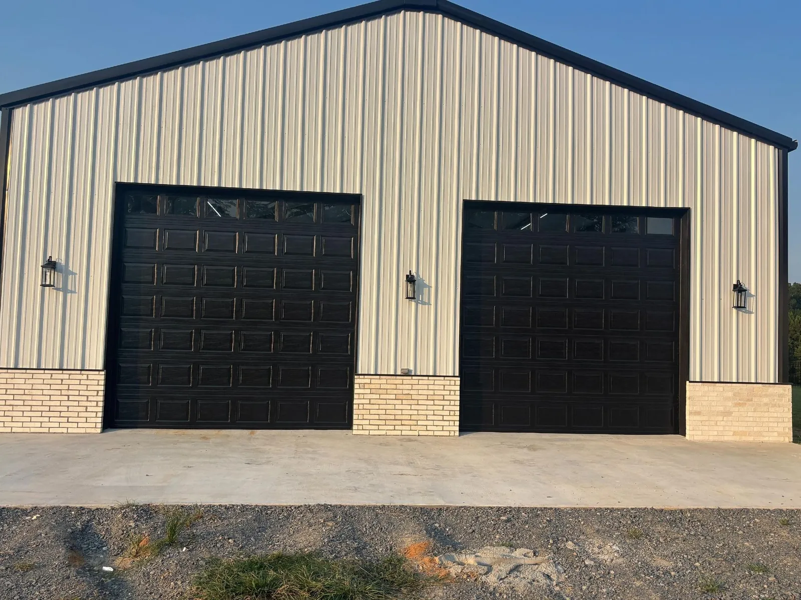 Metal building with two black roll-up doors